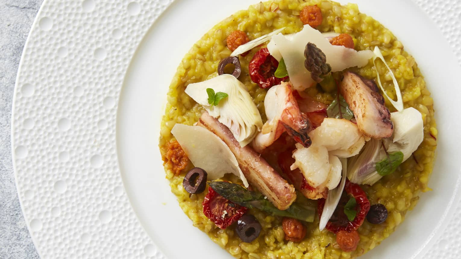 A seafood risotto dish served on a white plate