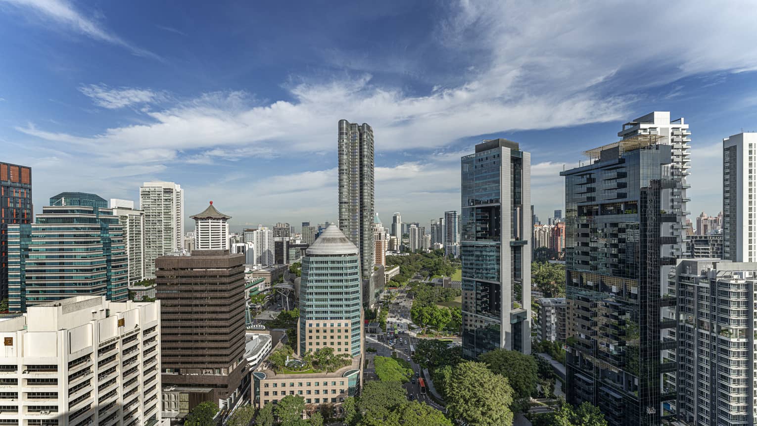 Bird's eye view of downtown Singapore, blue skies and trees