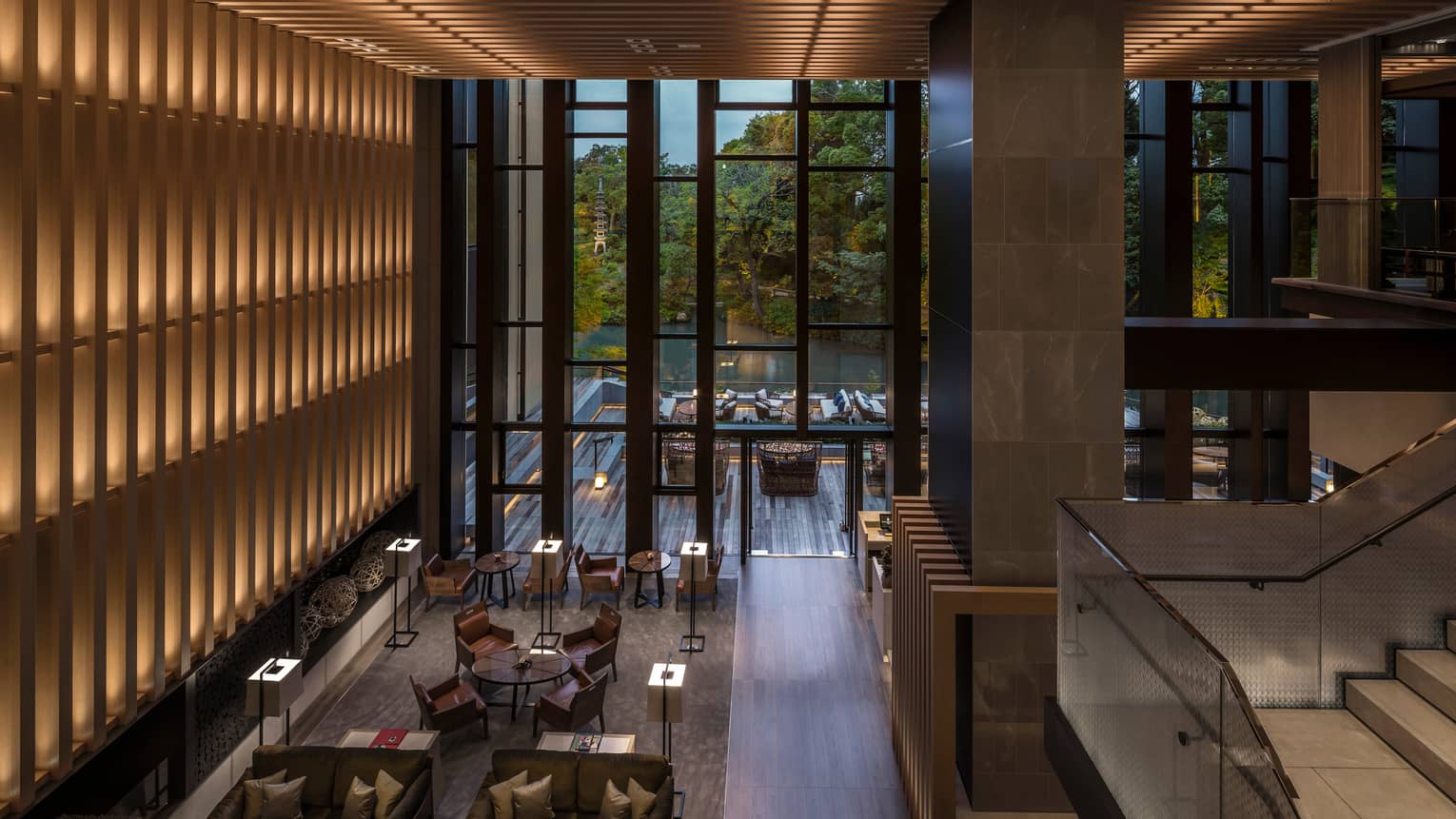 Looking down from soaring ceilings over Brasserie restaurant dining room, wood wall with lights