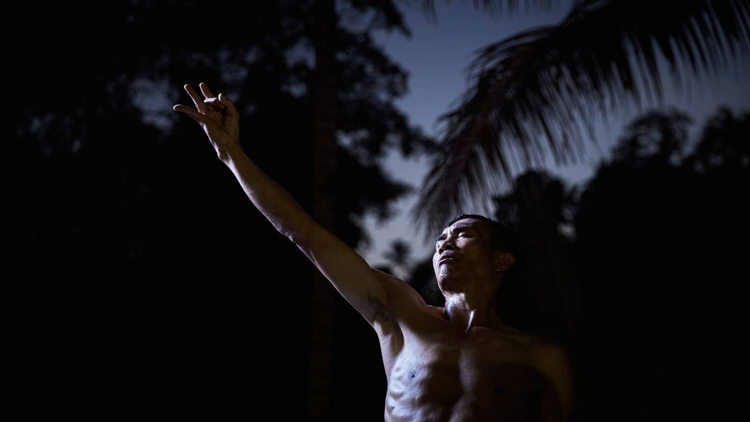 Man doing full moon purnama yoga in the Bali countryside