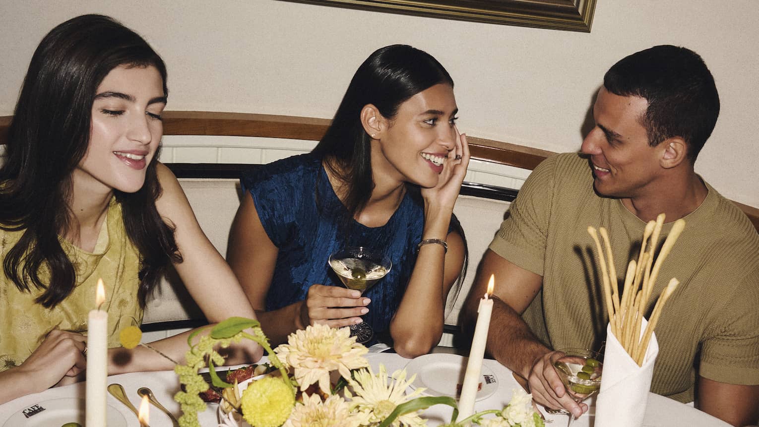 A group of people gather around a restaurant dining table