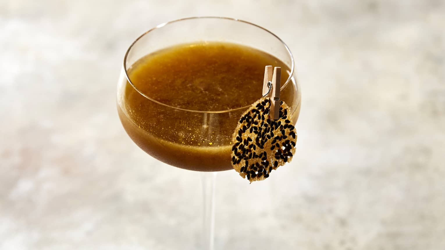 A lone chocolate martini sitting on a marble countertop. 