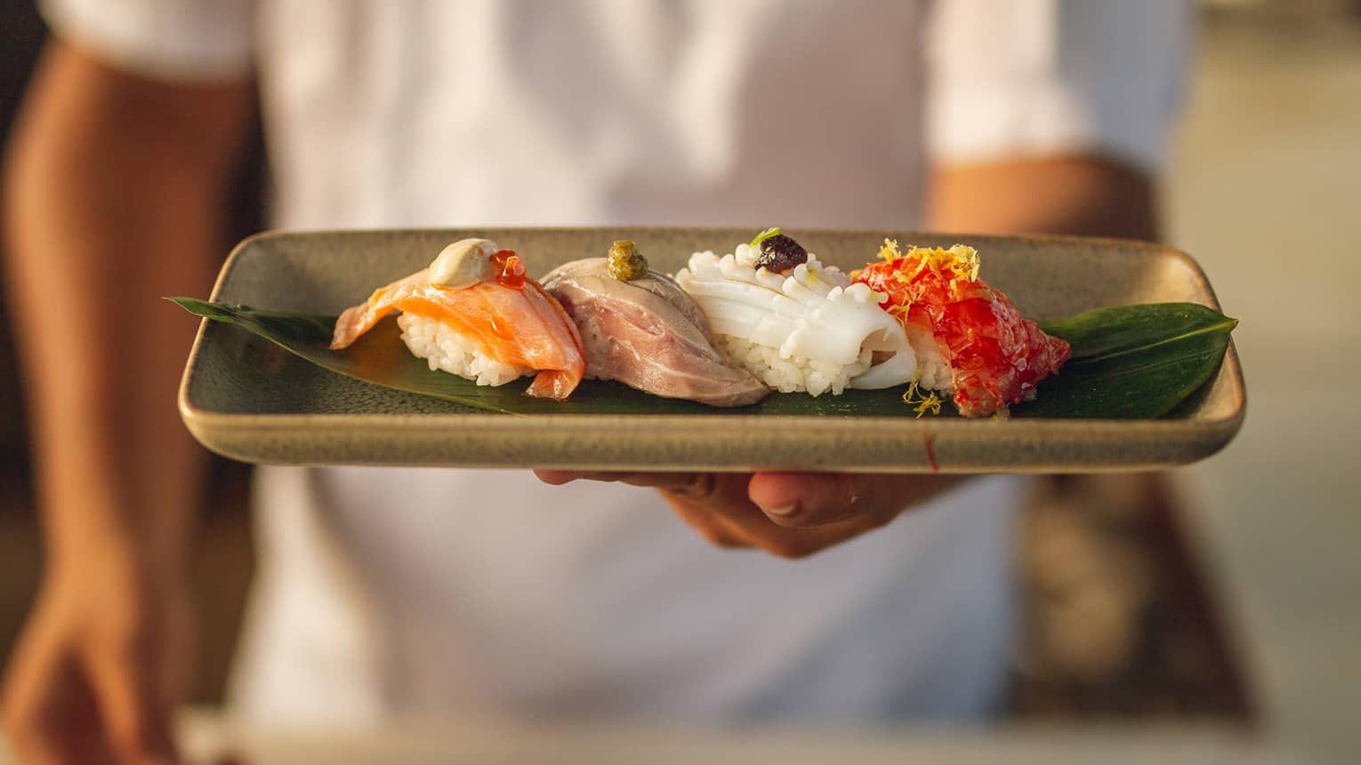 Chef holds a platter of nigiri selection