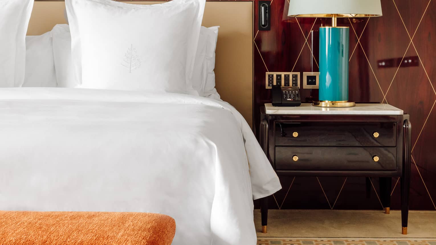 Hotel room bed and nightstand with turquoise lamp