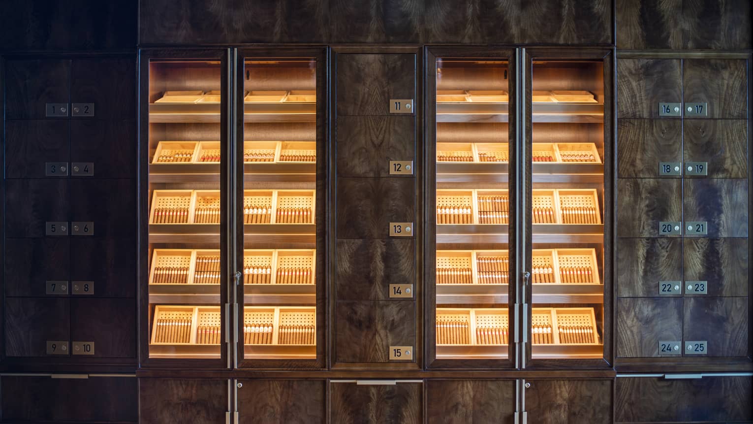Shelves of cigars behind glass doors.