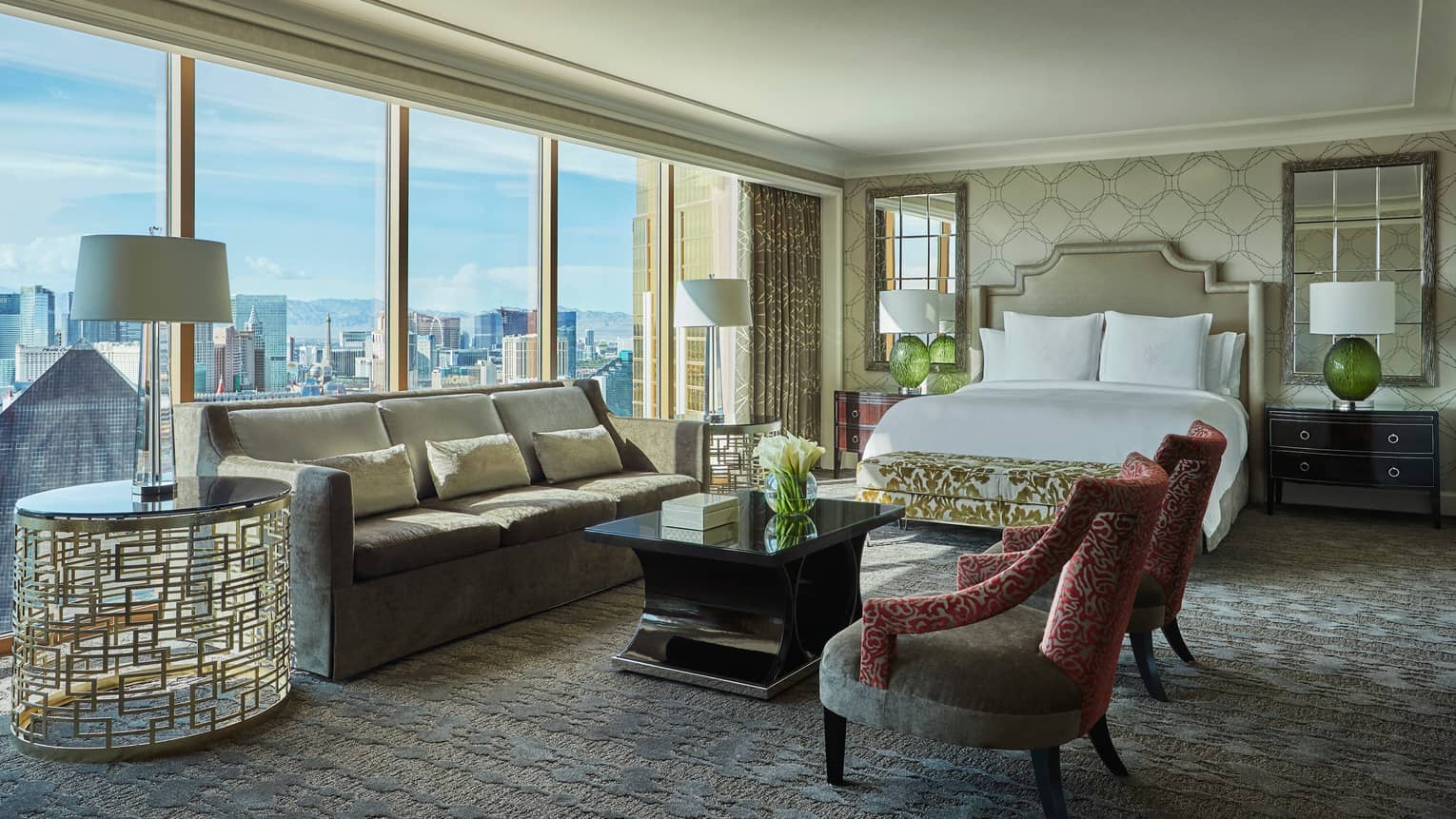 Strip-View Studio grey velvet sofa, gold accent chairs and table, floor-to-ceiling window, city views