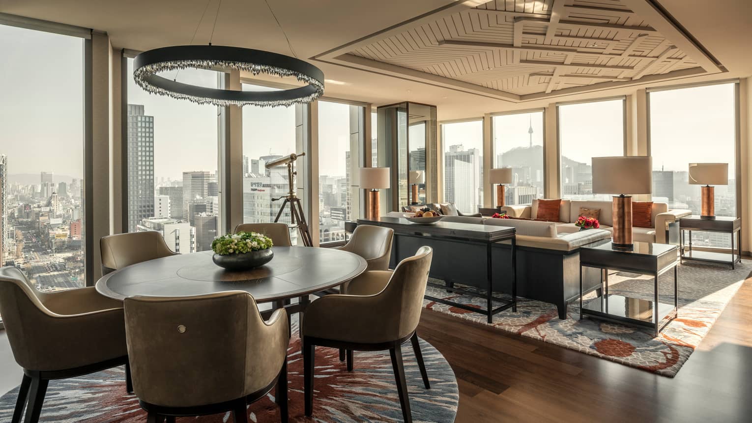 Sejong Two-Bedroom Suite round dining table under modern chandelier, seating area, corner windows