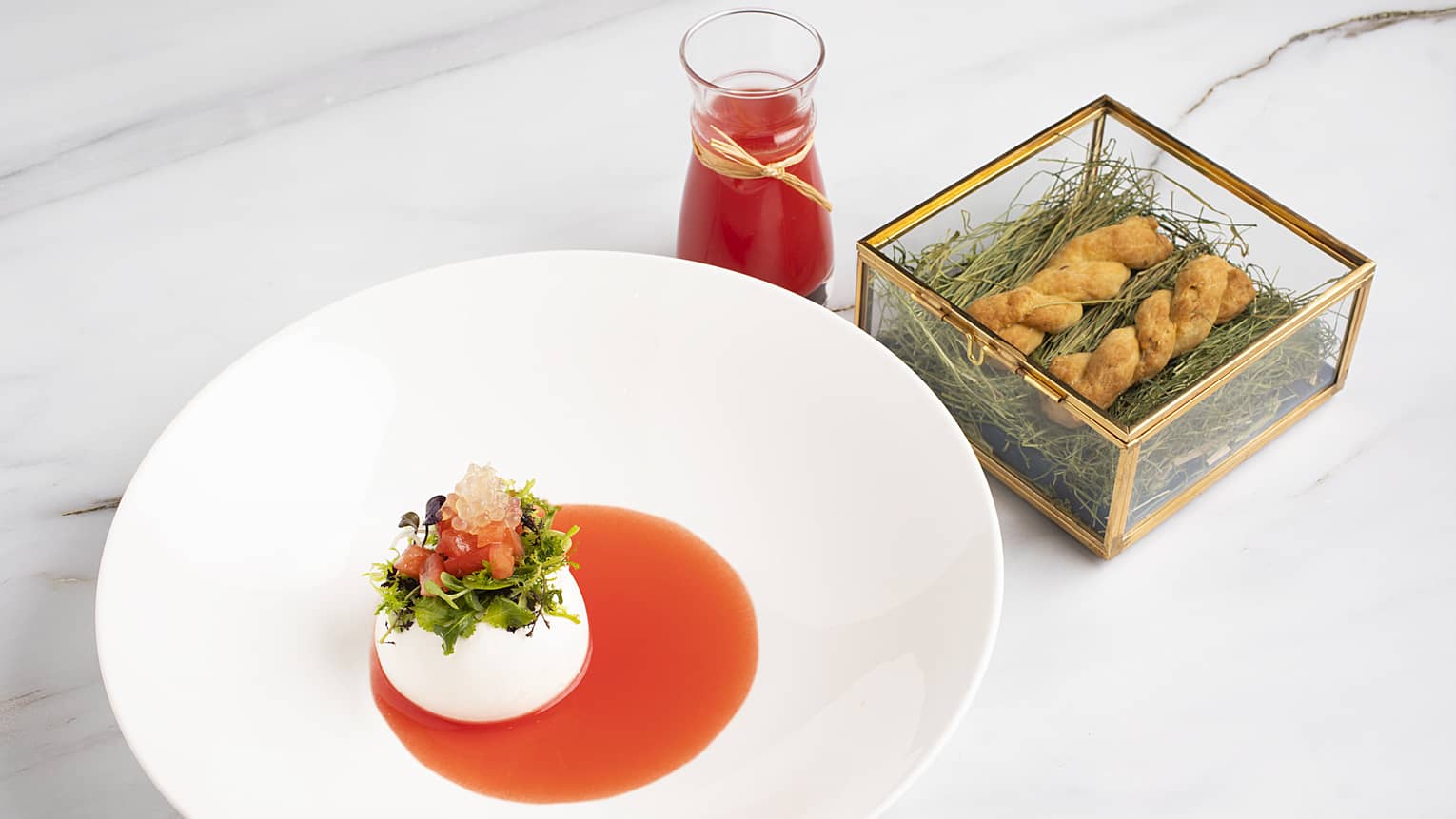 A white porcelain dish with red sauce and cream in the bottom.