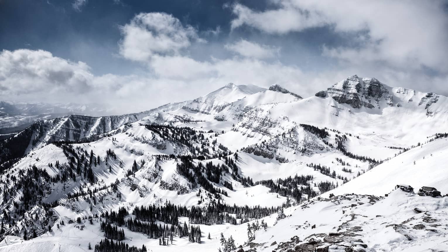 Aerial view of Jackson Hole Mountain Resort with mountains peaks covered in snow, pine trees