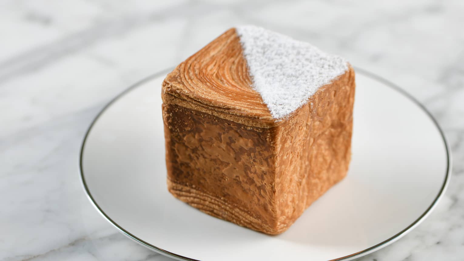 Le Cube Robuchon Vanilla ?�A pastry cube with a triangle of white powdered sugar on the top