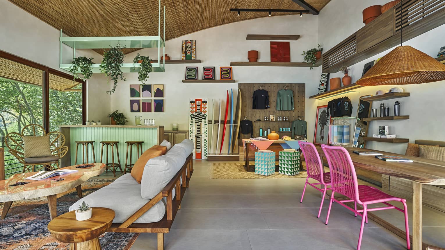 Indoor surf patio with futon and coffee table, service desk, wooden table with pink chairs
