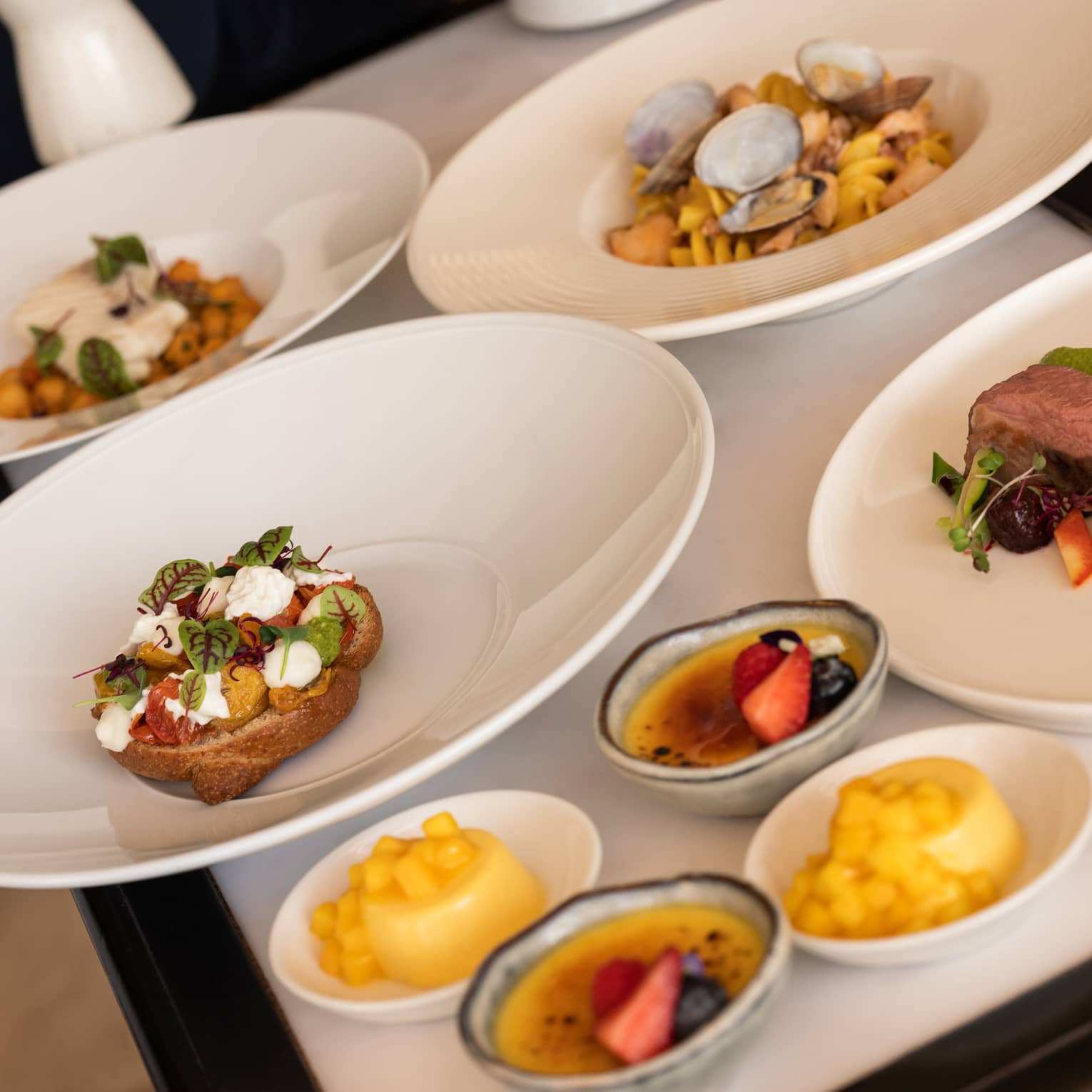 Cart filled with various white plates of food and desserts