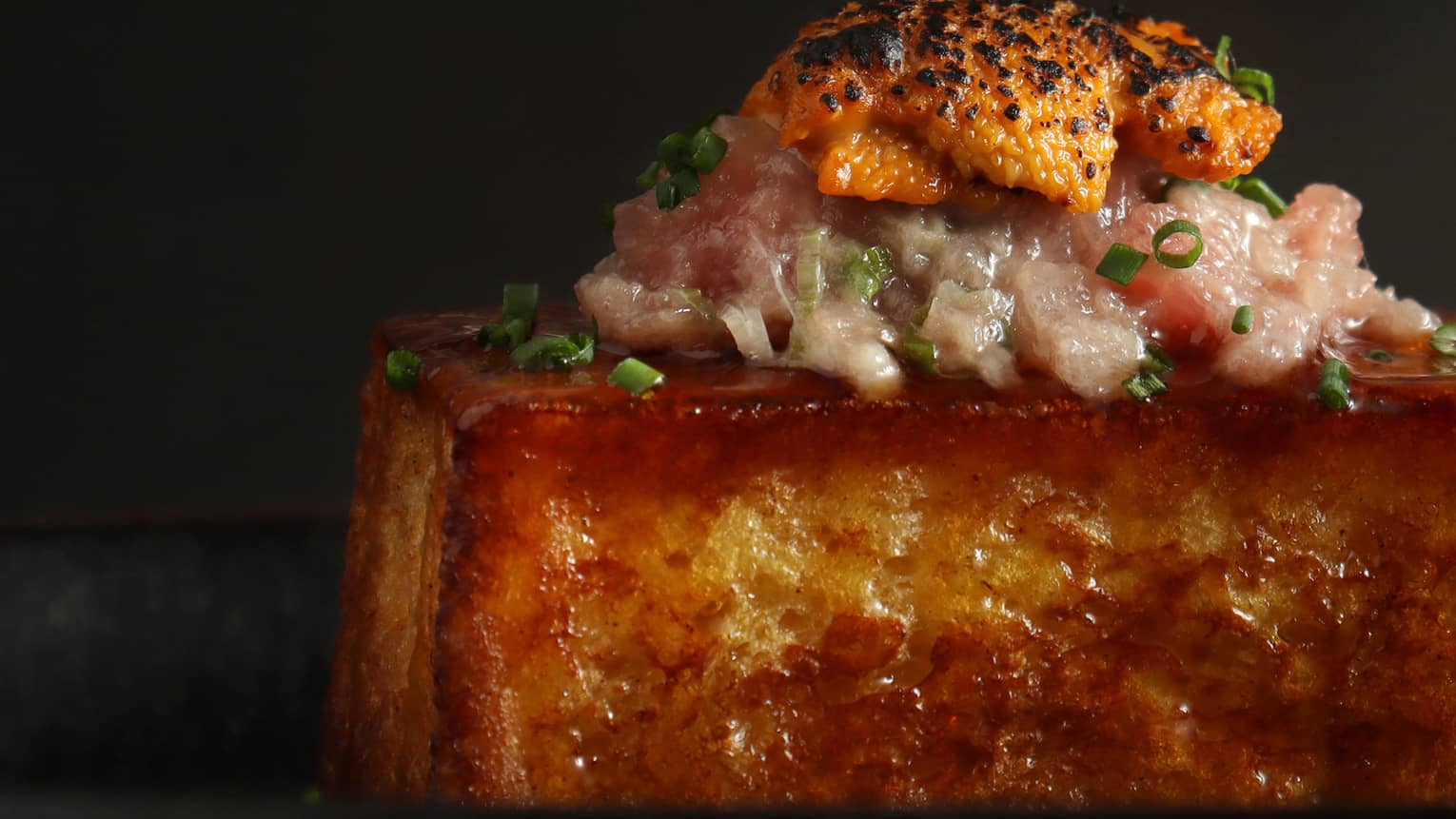 A large piece of toast with a pink garnish.
