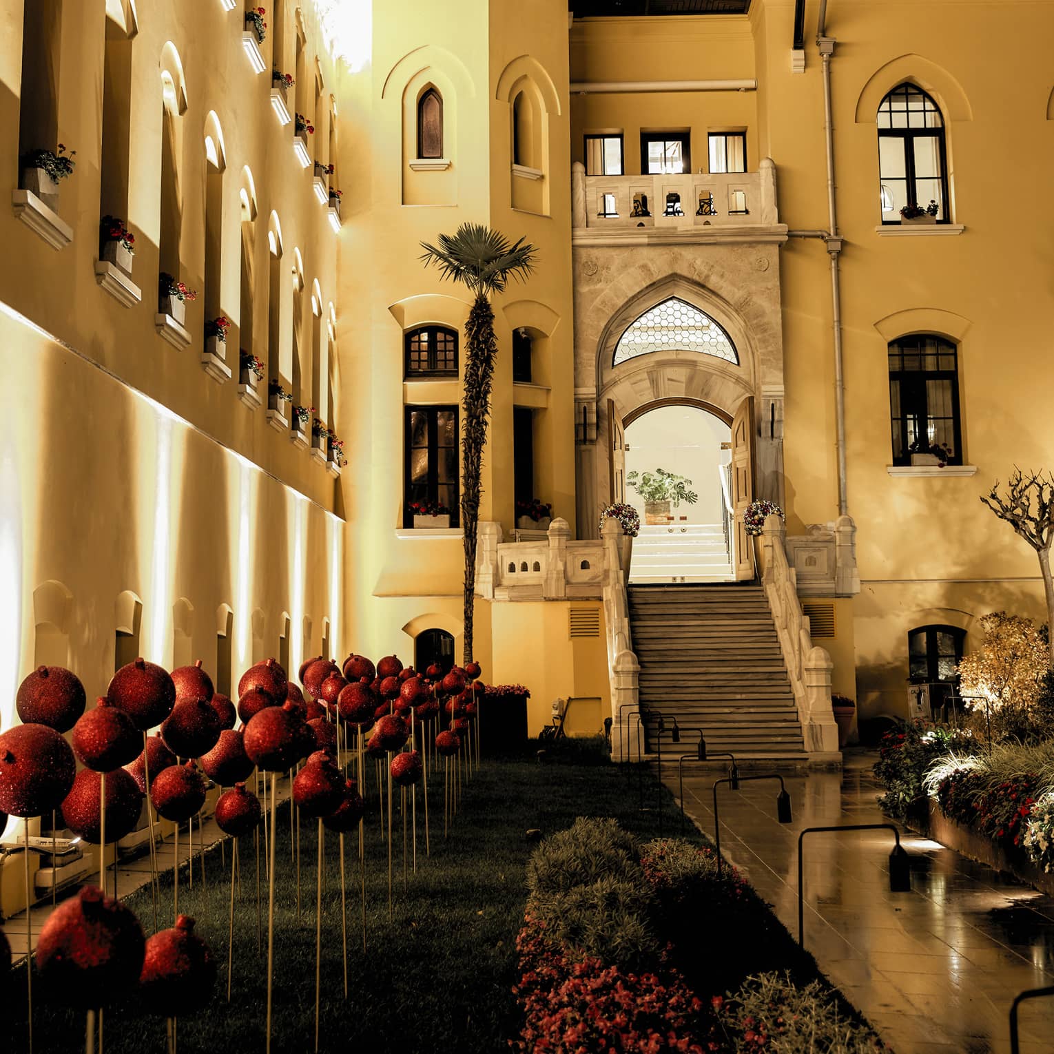 Hotel courtyard with red holiday decor uplit at night