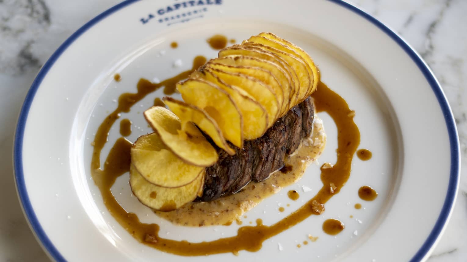 Steak frites on a white plate.