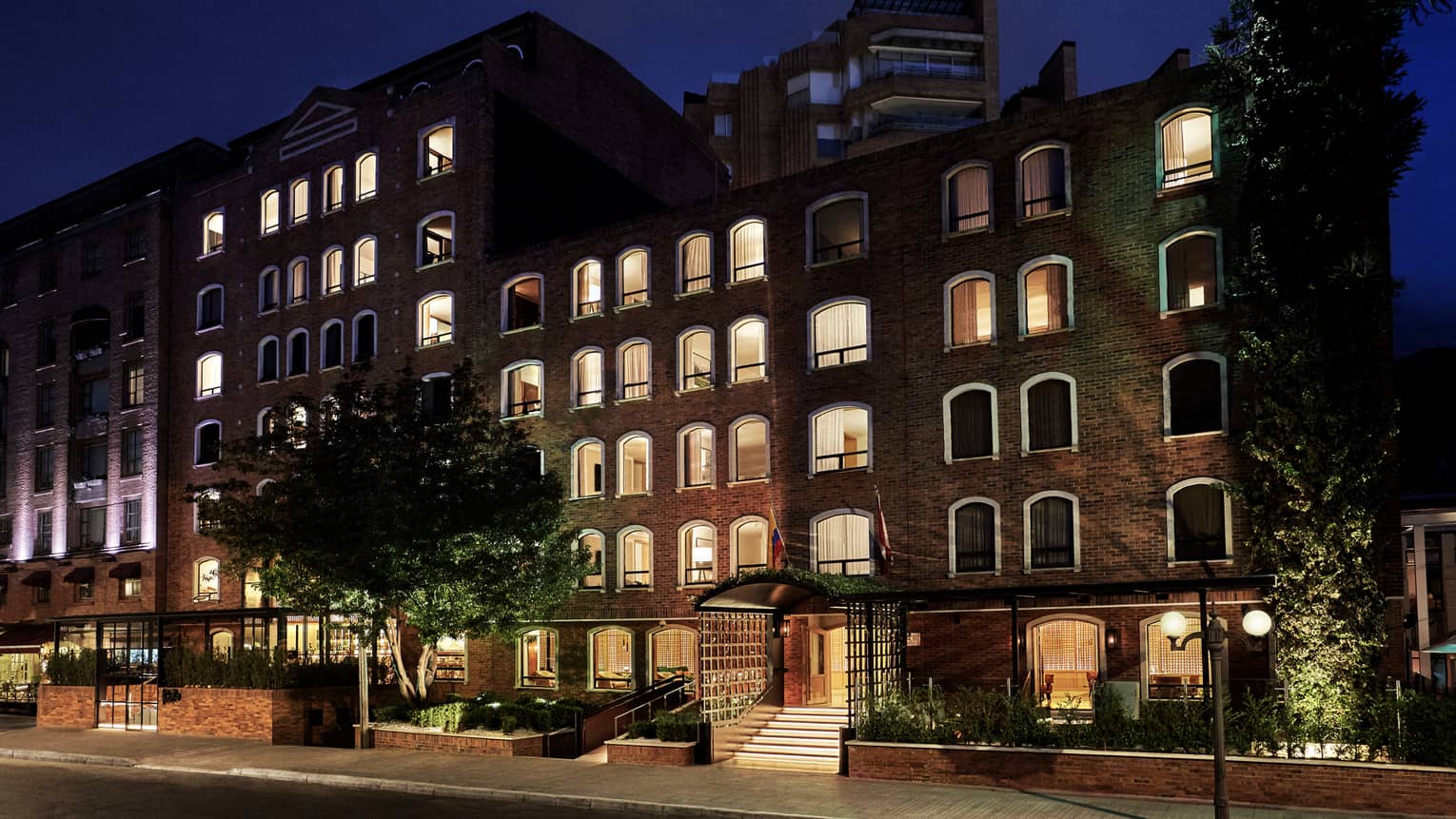 Night view of Bogota hotel brick low rise exterior with lights in windows