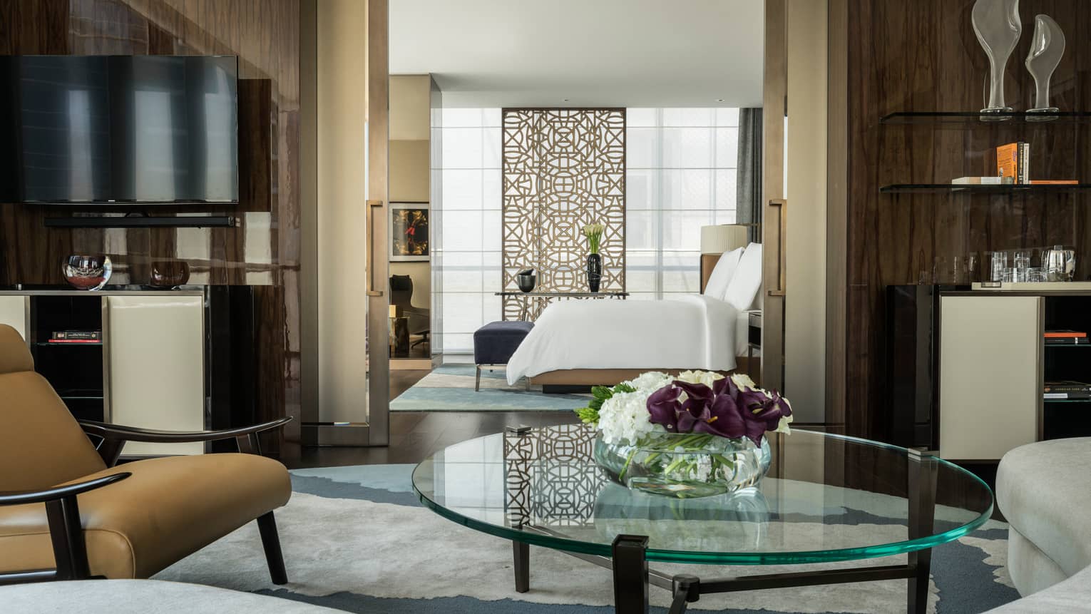 Four Seasons Deluxe Executive Suite living room with round glass coffee table, door to bedroom