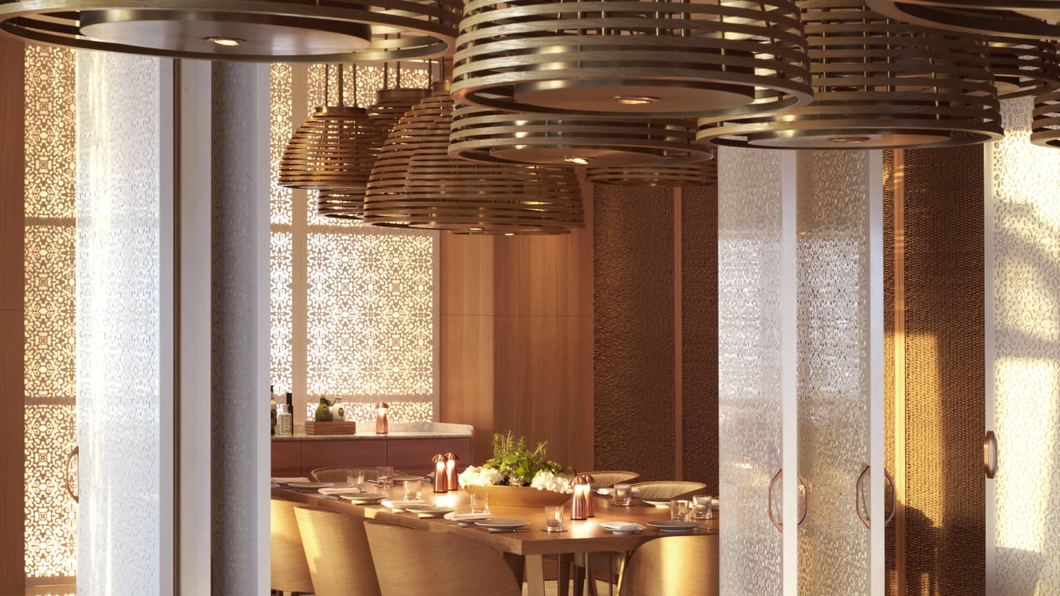 Large overhead lamps hang over a long mahogany table.