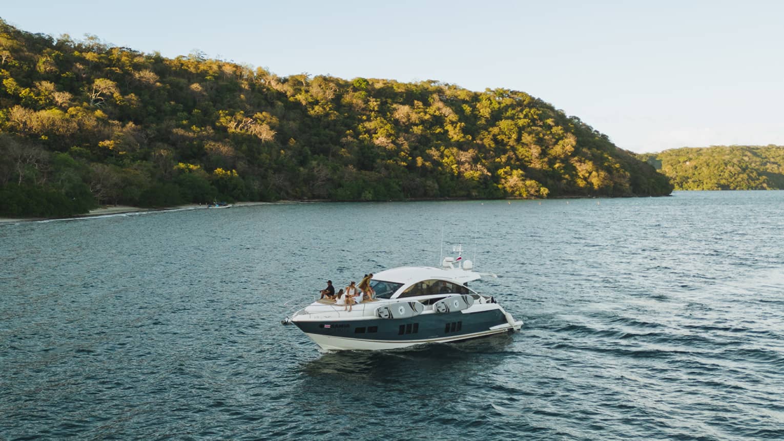 Power boat on water near green hills
