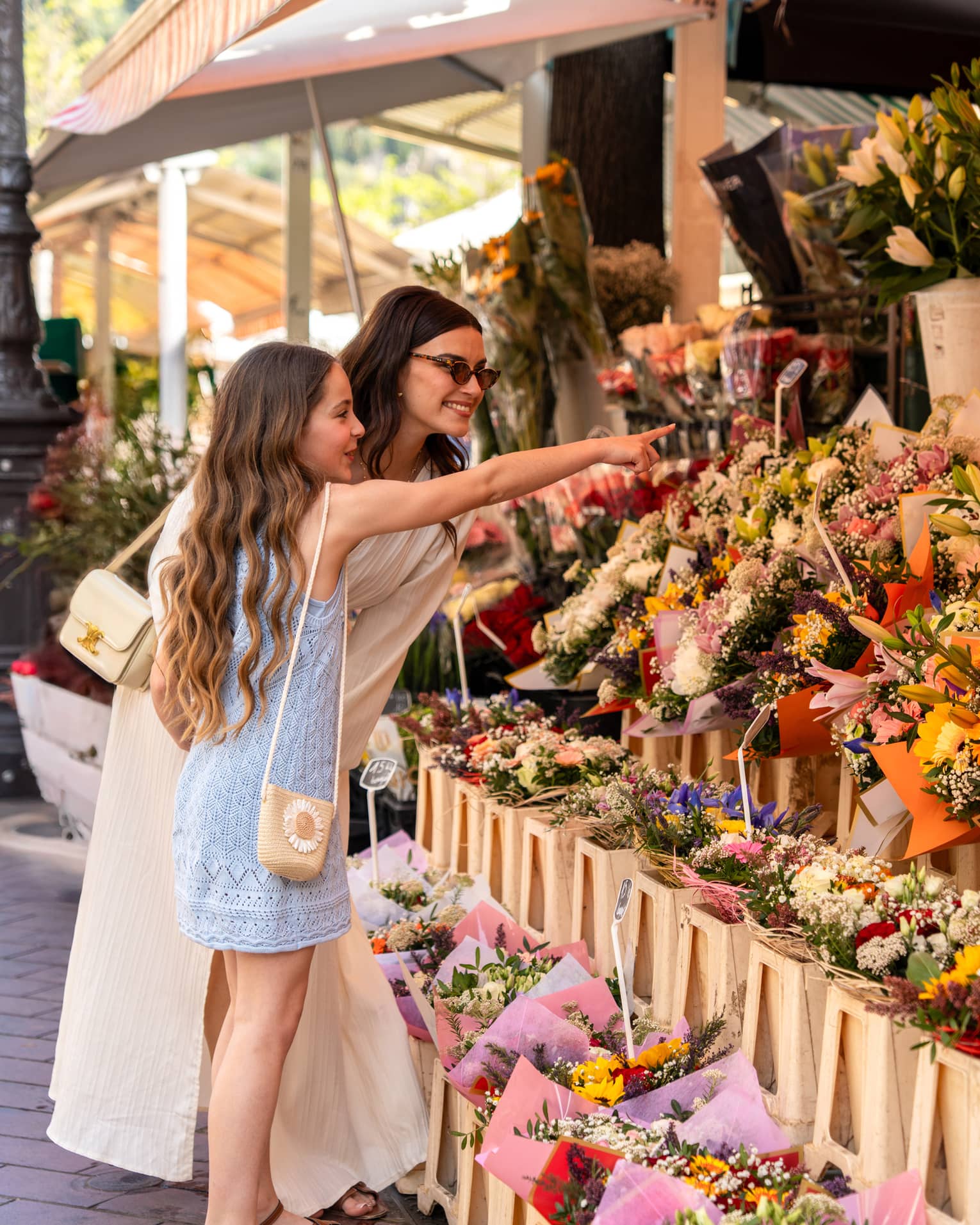 Two guests standing near a display of flowers at an outdoor shop
