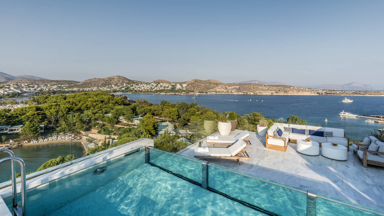 Arion Riviera Suite Rooftop with plunge pool, lounge area below with white sofa and dining table, view of the Mediterranean Sea