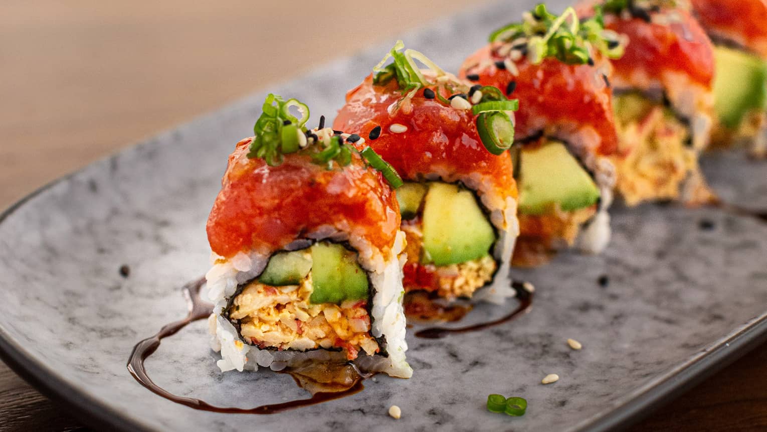 A sushi roll on a grey plate.