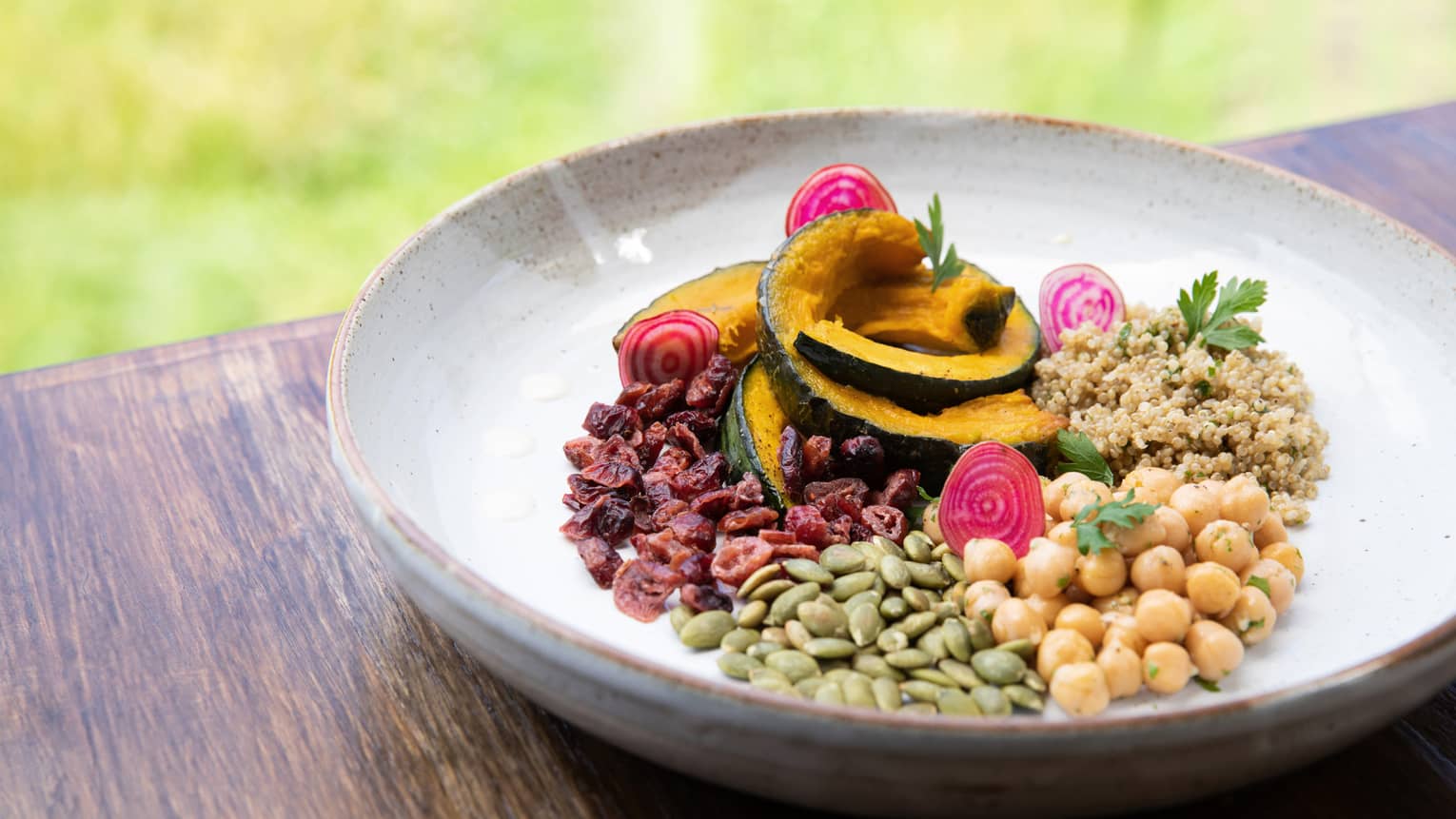 A bowl filled with a variety of grains and sliced mango. 