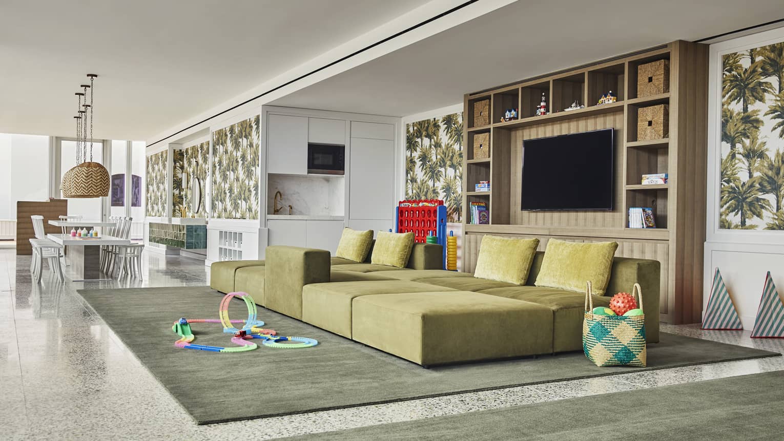 Bright kids facility with craft table, large sofa, toys and games. Specially-trained staff entertain children