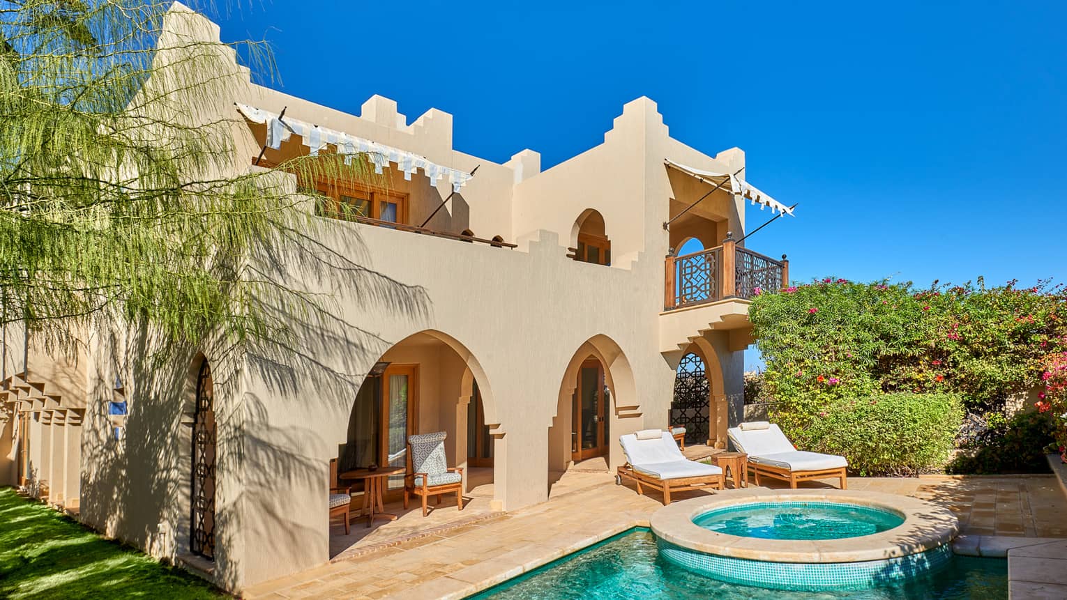Exterior view of four bedroom villa and private pool against blue sky