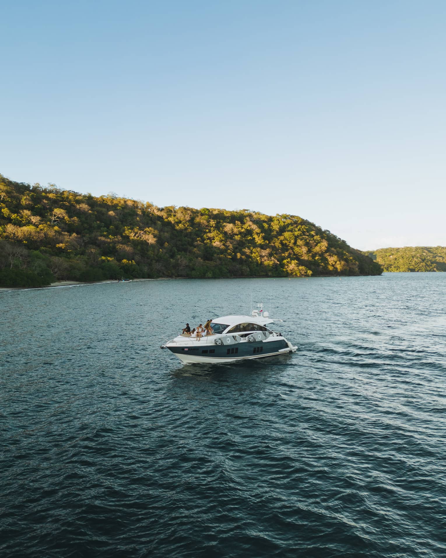 Power boat on water near green hills
