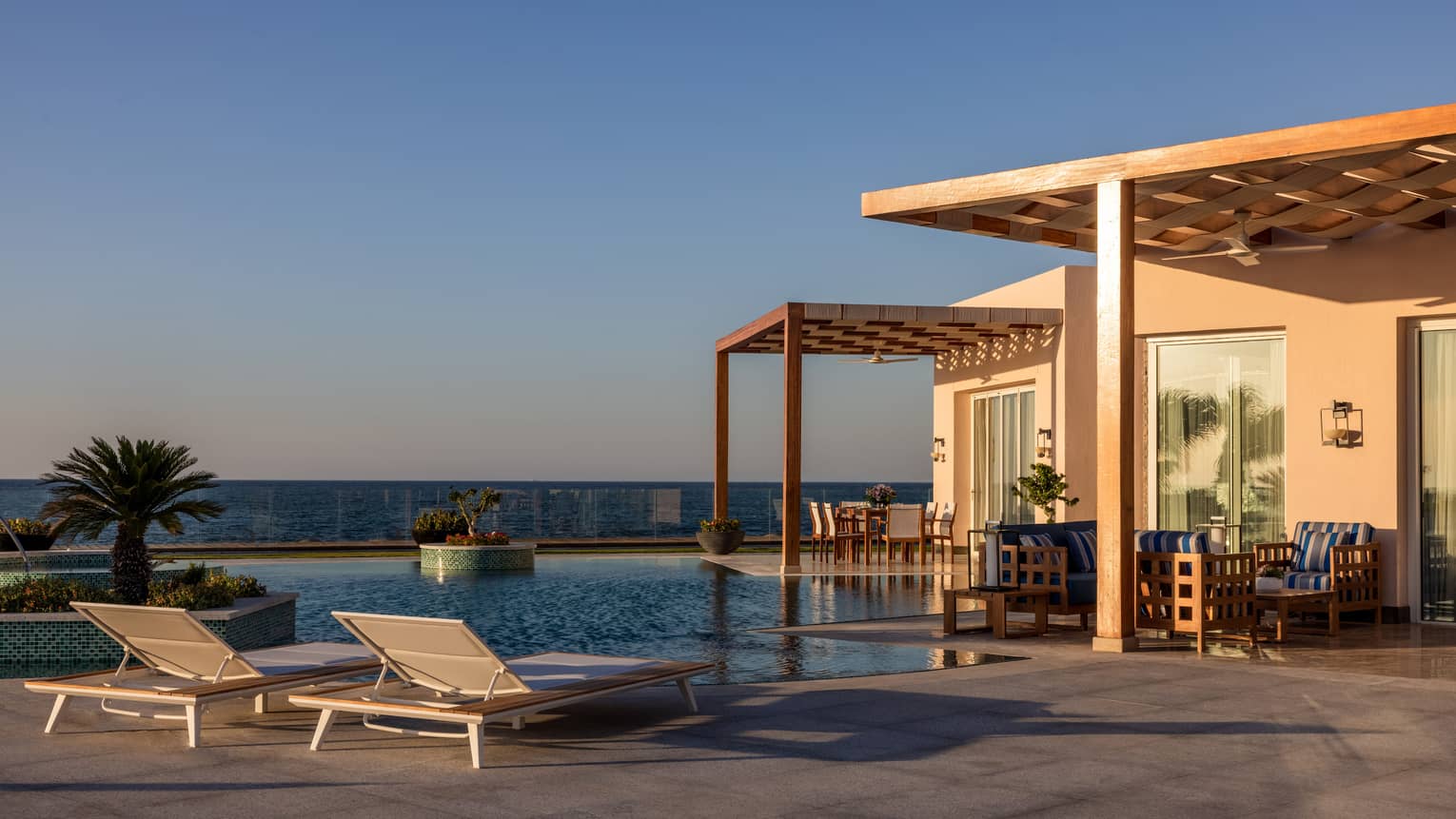 Pool and lounge chairs on patio of The Palace at dusk