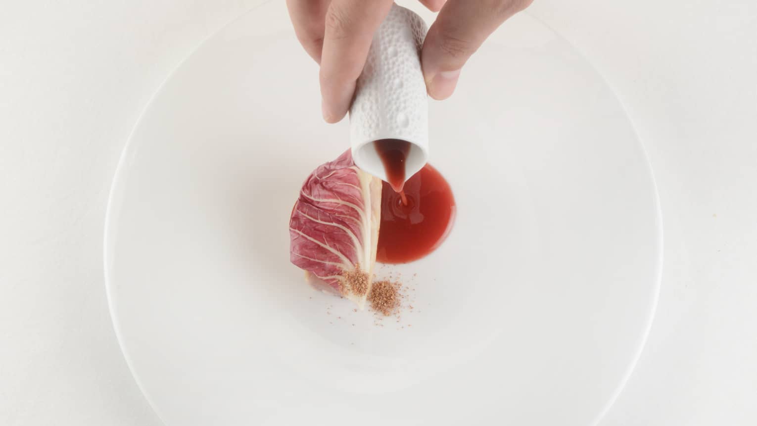  Mediterranean amberjack with apple, butter and endive being served on white plate
