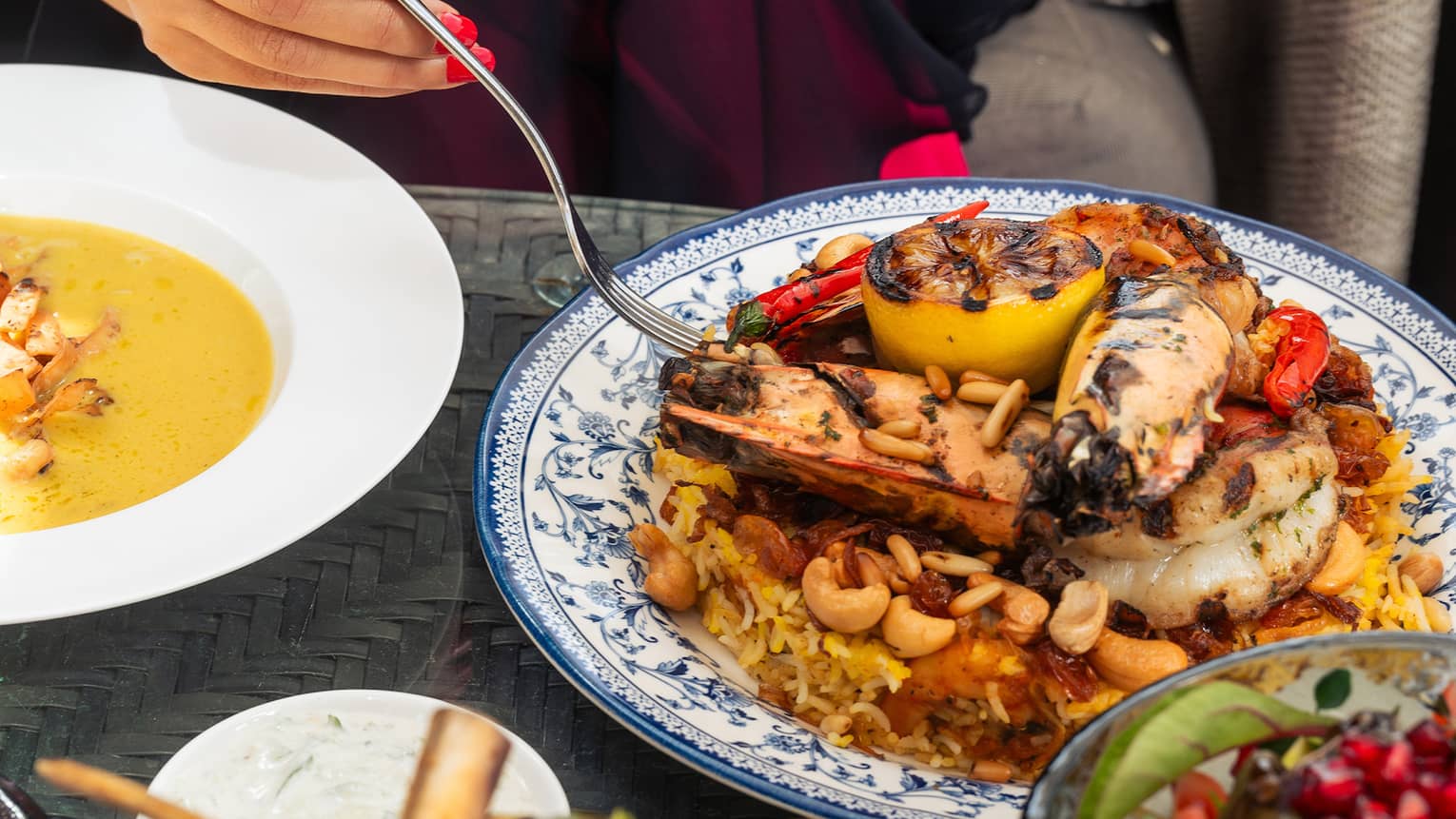 A person holds a fork, ready to eat middle eastern food