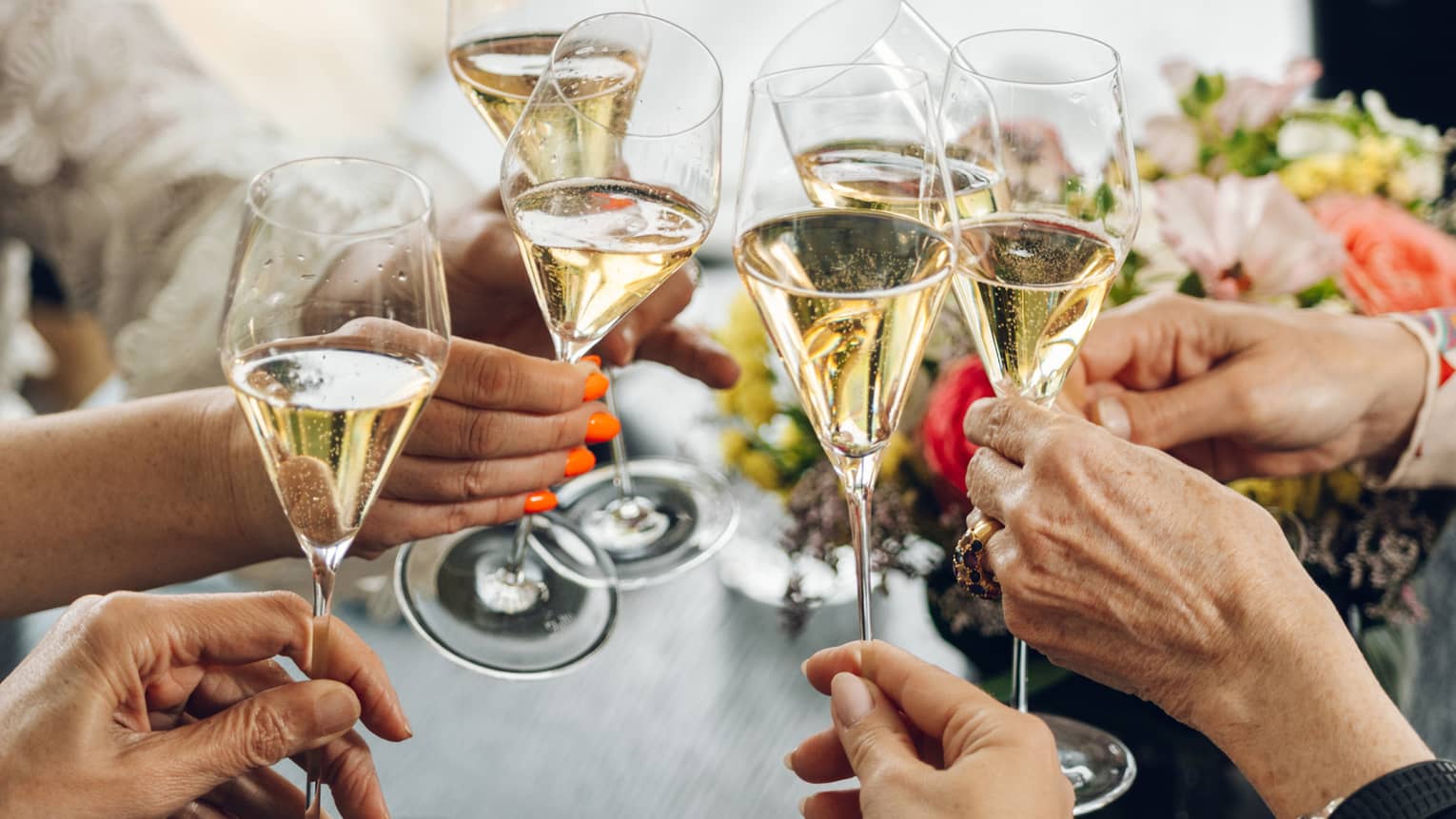 A group of guests toast glasses of champagne at a dining table