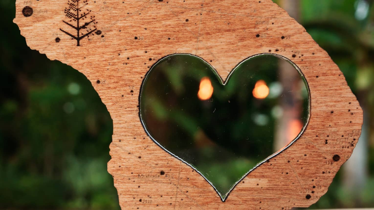 A heart-shaped wooden cutout on a table in a Hawaiian setting