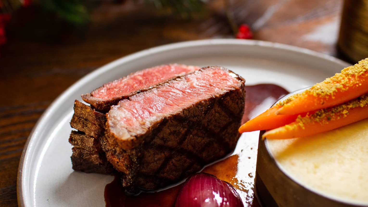 Steak with a red sauce on a grey plate.