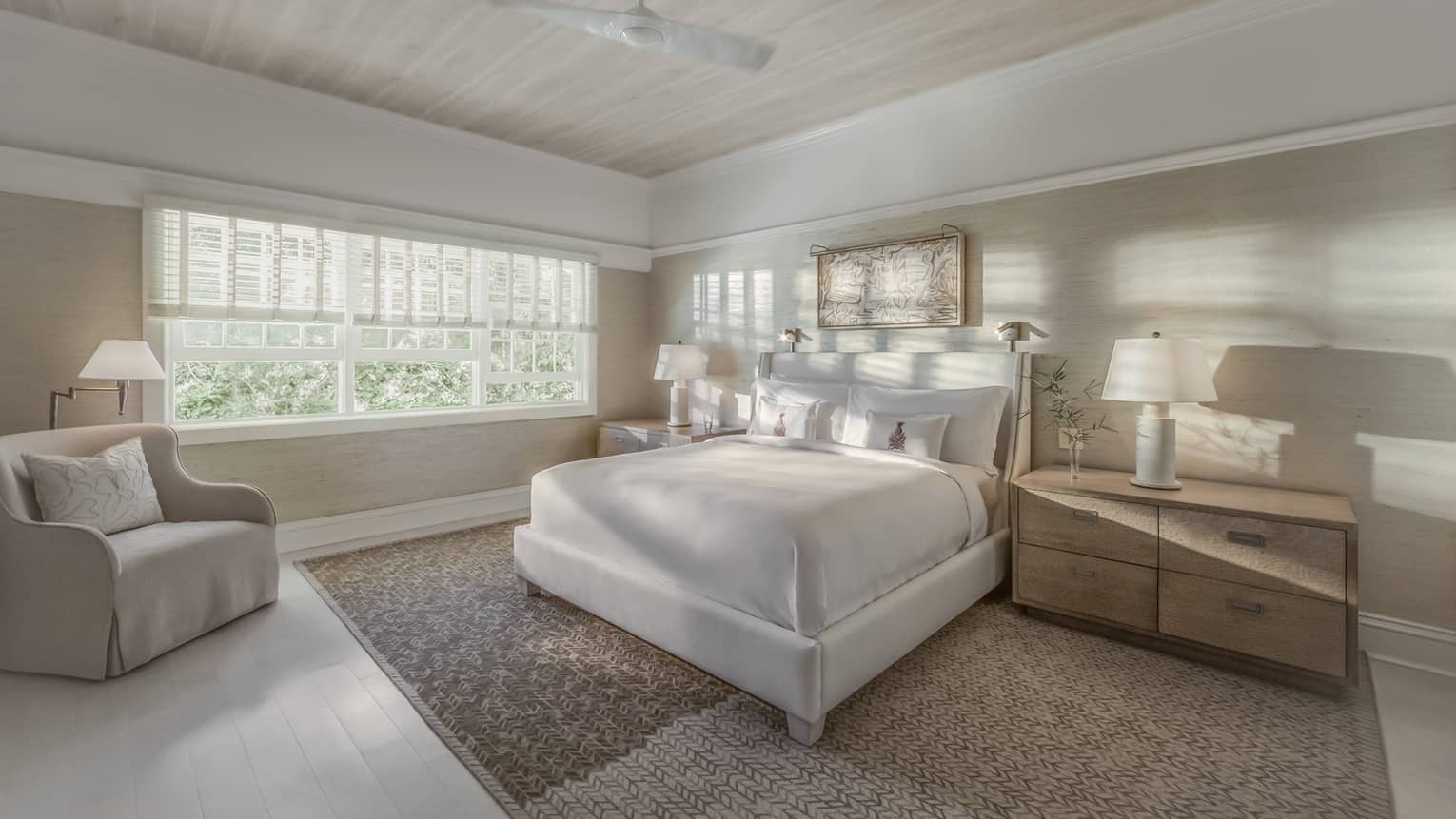 Sunlight and shadows shine through the window of a master suite bedroom