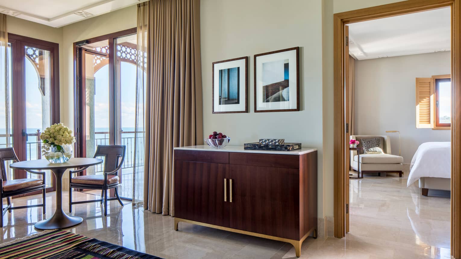 Four Seasons Sea-View Suite wood vanity with bowl of plums, small dining table by sunny window