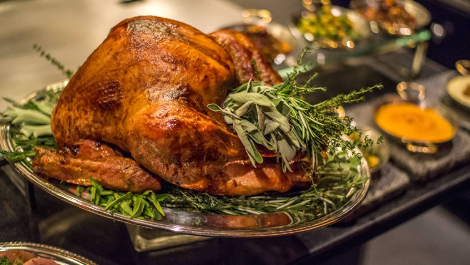Roast turkey with fresh herbs on silver platter