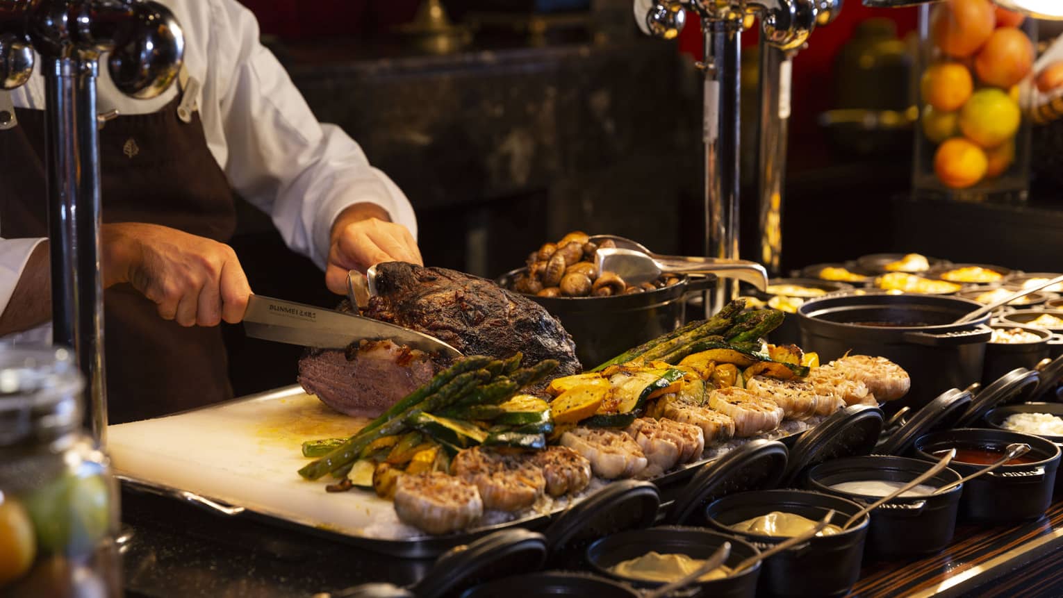 Festive holiday buffet with chef preparing food