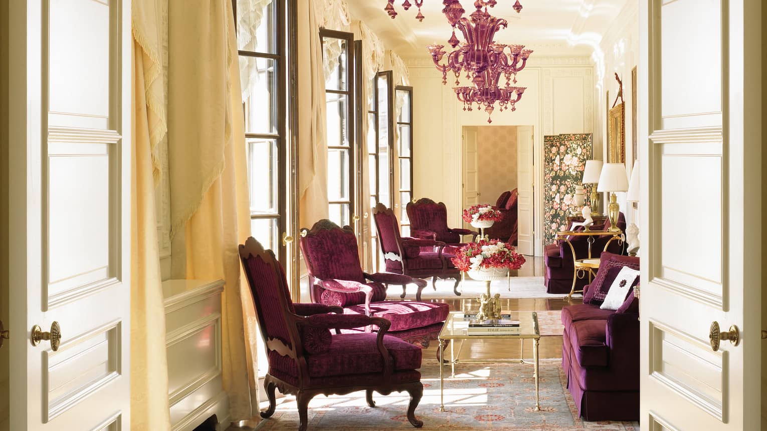 Sunny Presidential Suite purple velvet armchairs, loveseat under purple crystal chandelier