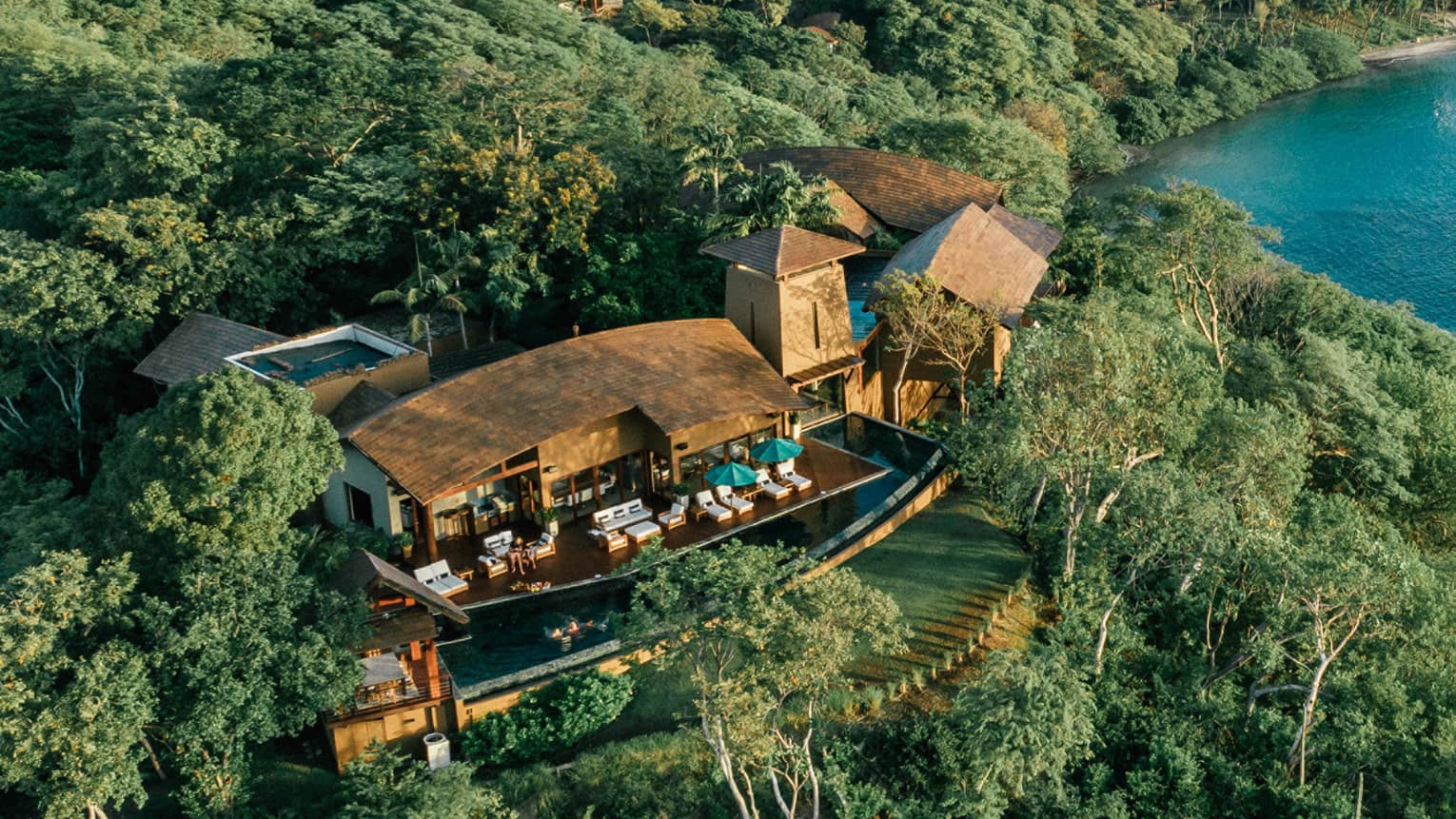 An aerial view of four seasons hotel costa rica surrounded by lush vegetation and the ocean