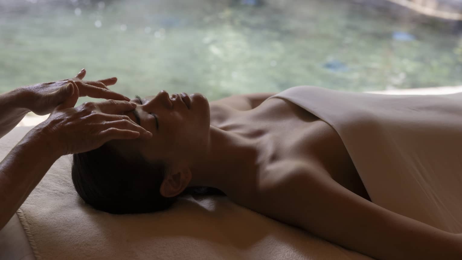 Woman gets spa treatment next to pool