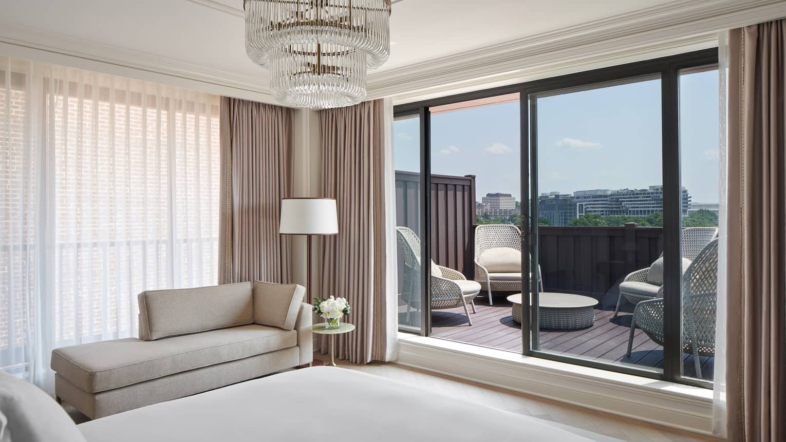View from the bedroom of a walk-out private terrace with four wing-back chairs, in the Georgetown Suite at Four Seasons Hotel Washington, DC