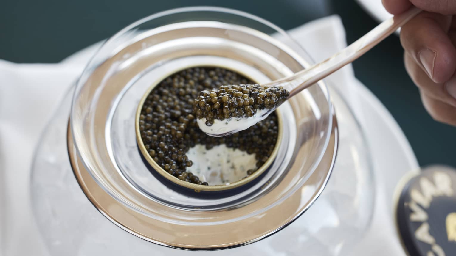 Man scoops a spoonful of Kristal caviar out of a tin