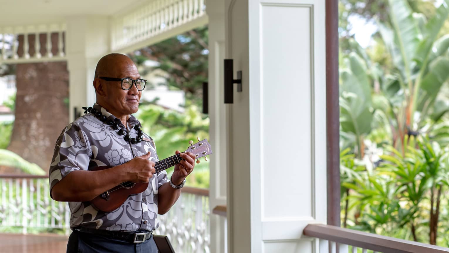 K?naka Maoli elder plays the ukelele on the second-story wraparound porch of the Resort