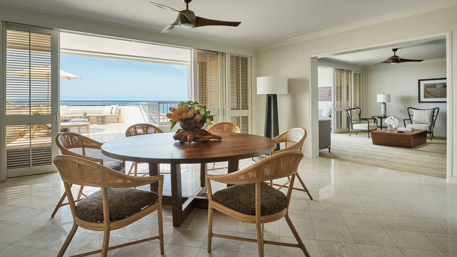 Residence dining room with round wood table retro wicker seats, sliding balcony shutters