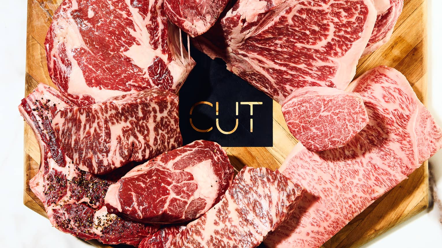 Slices of beef on a cutting board with "Cut" written on it.