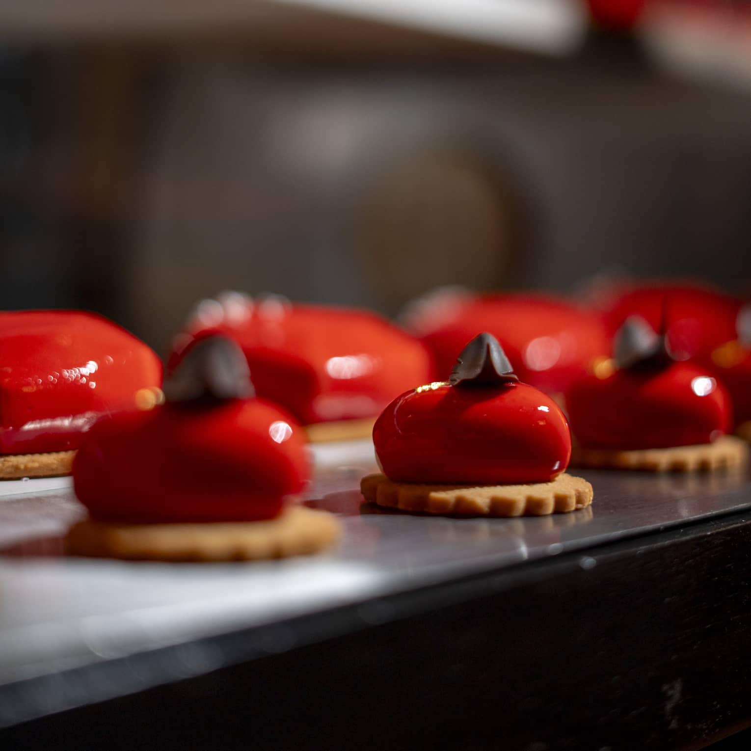 Bright red heart-shaped mini cakes lines up in a row