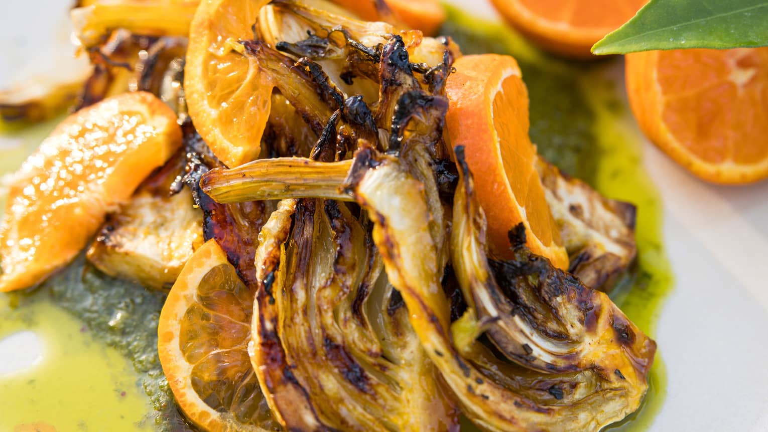 Roasted fennel served with salsa verde and fresh orange slices